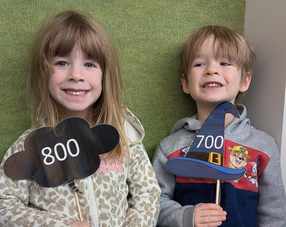A boy and a girl with signs that say 800 and 700