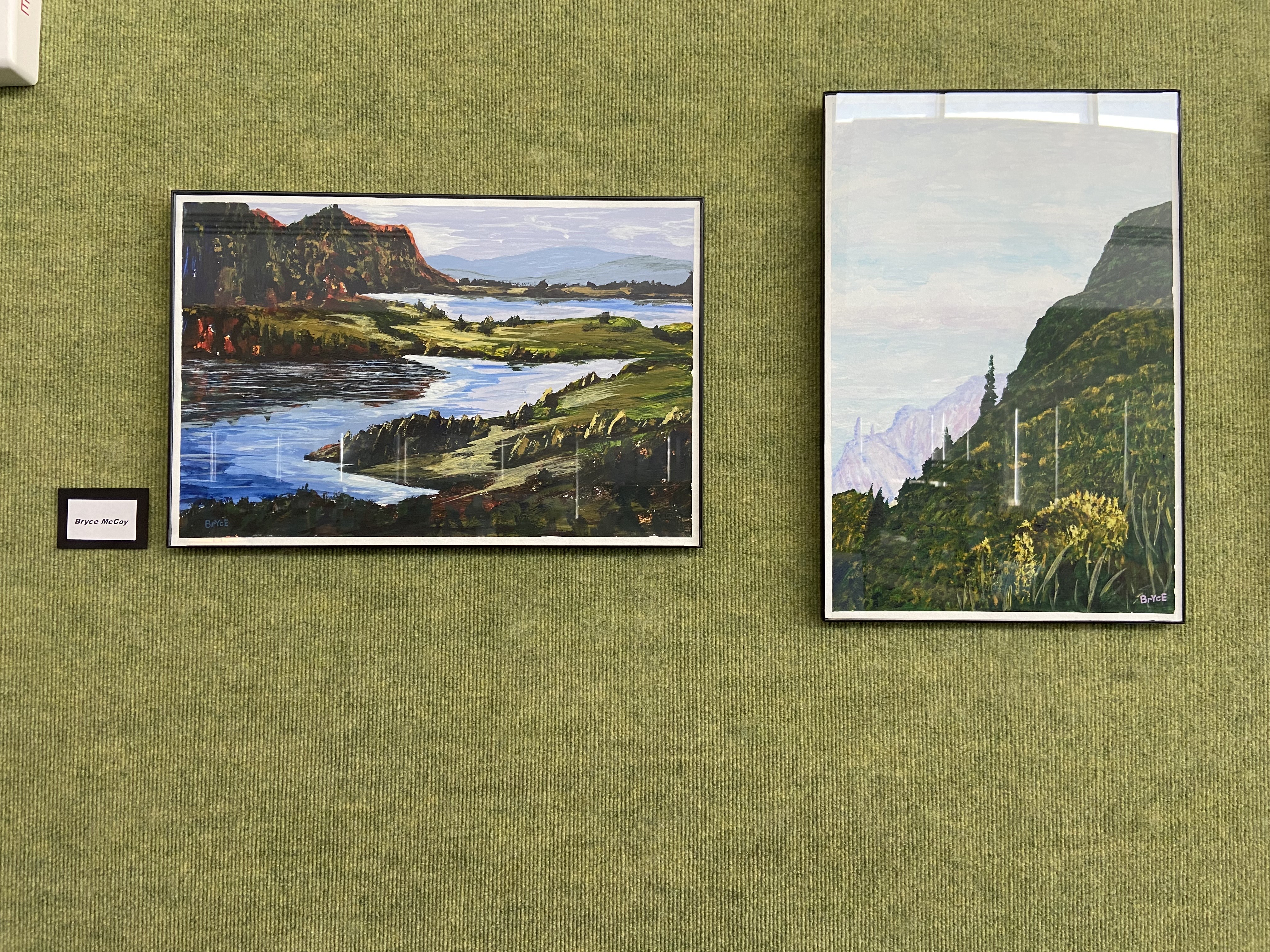 green textured background with framed landscape paintings