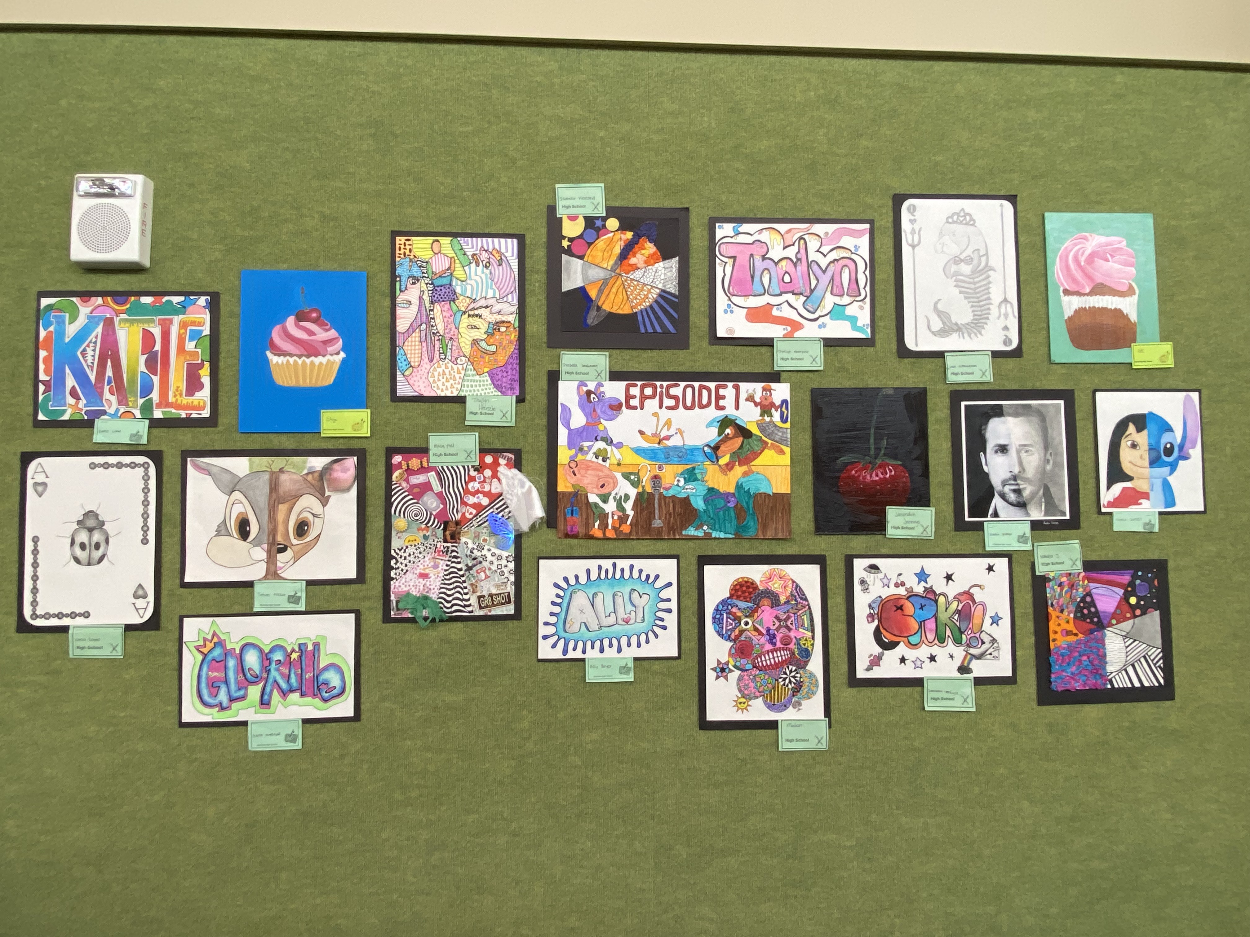 variety of art on green wall with labels