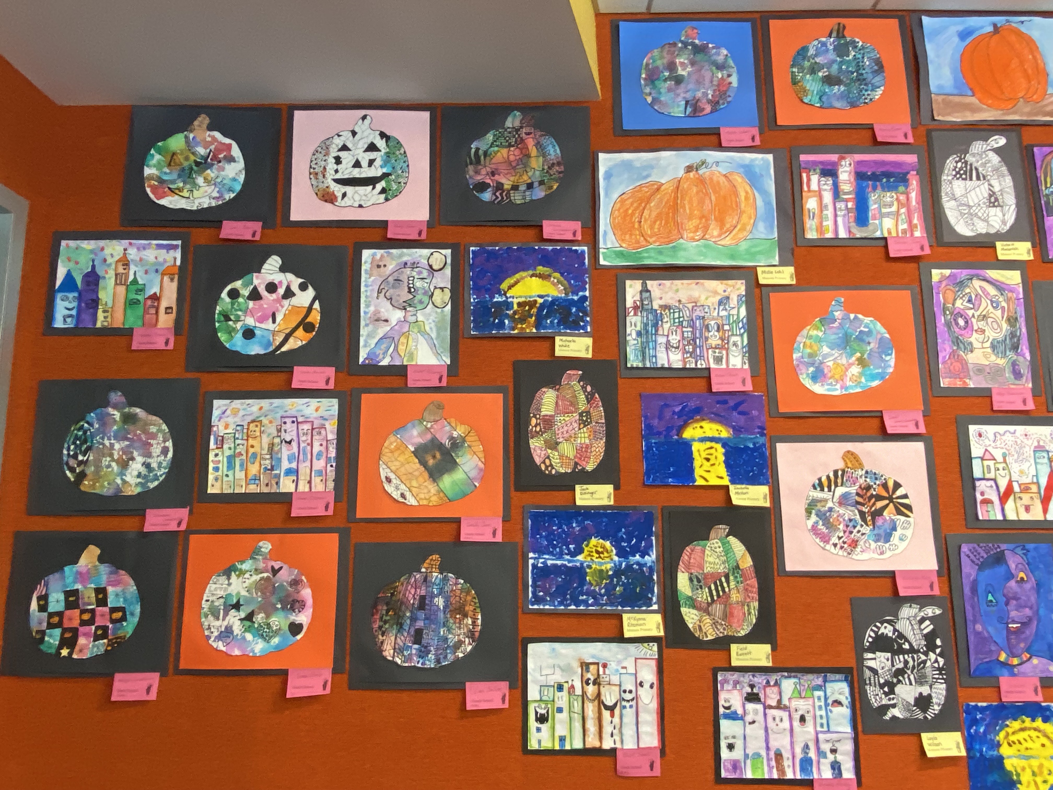 variety of art on green wall with labels