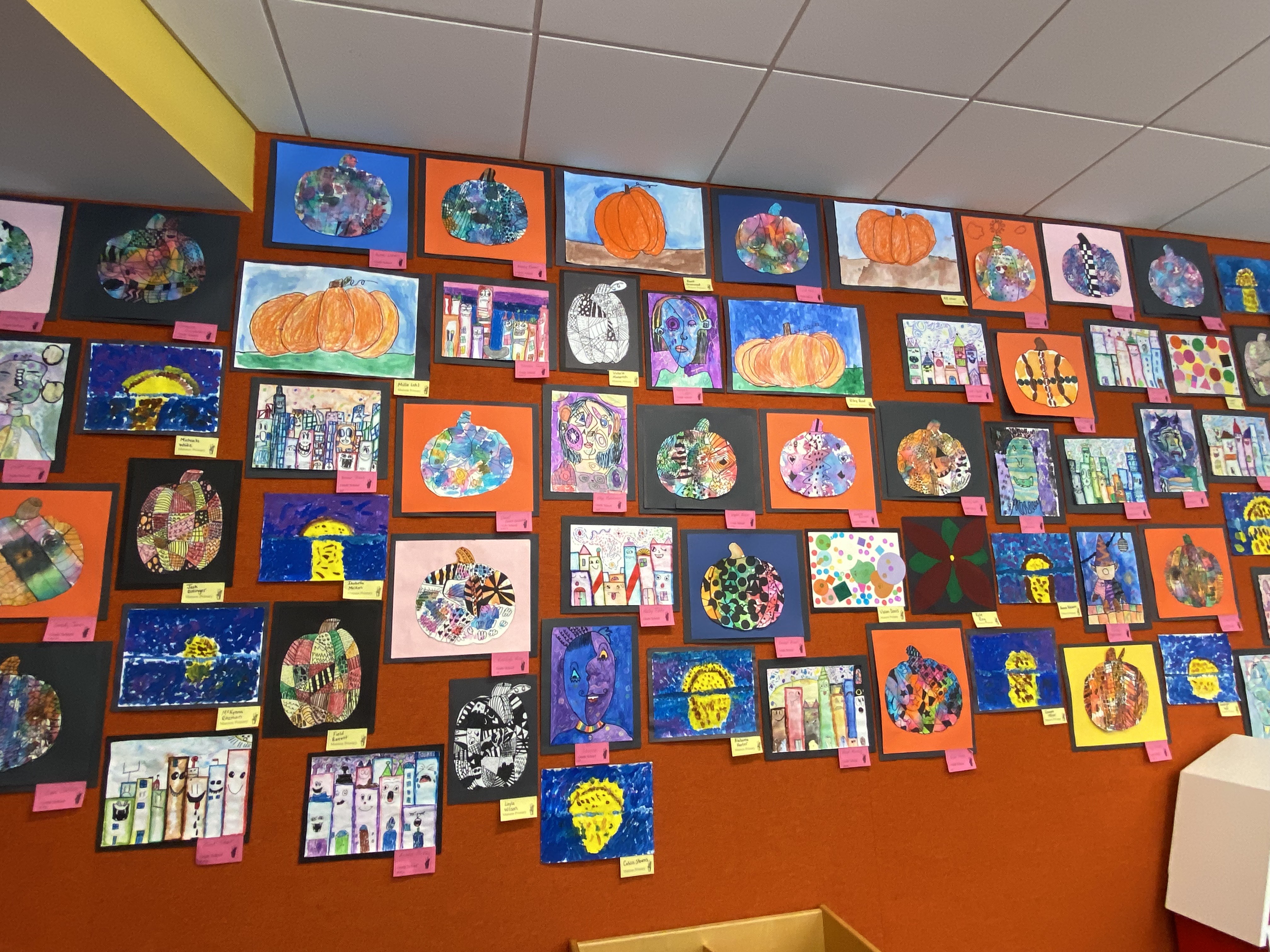 variety of art on green wall with labels