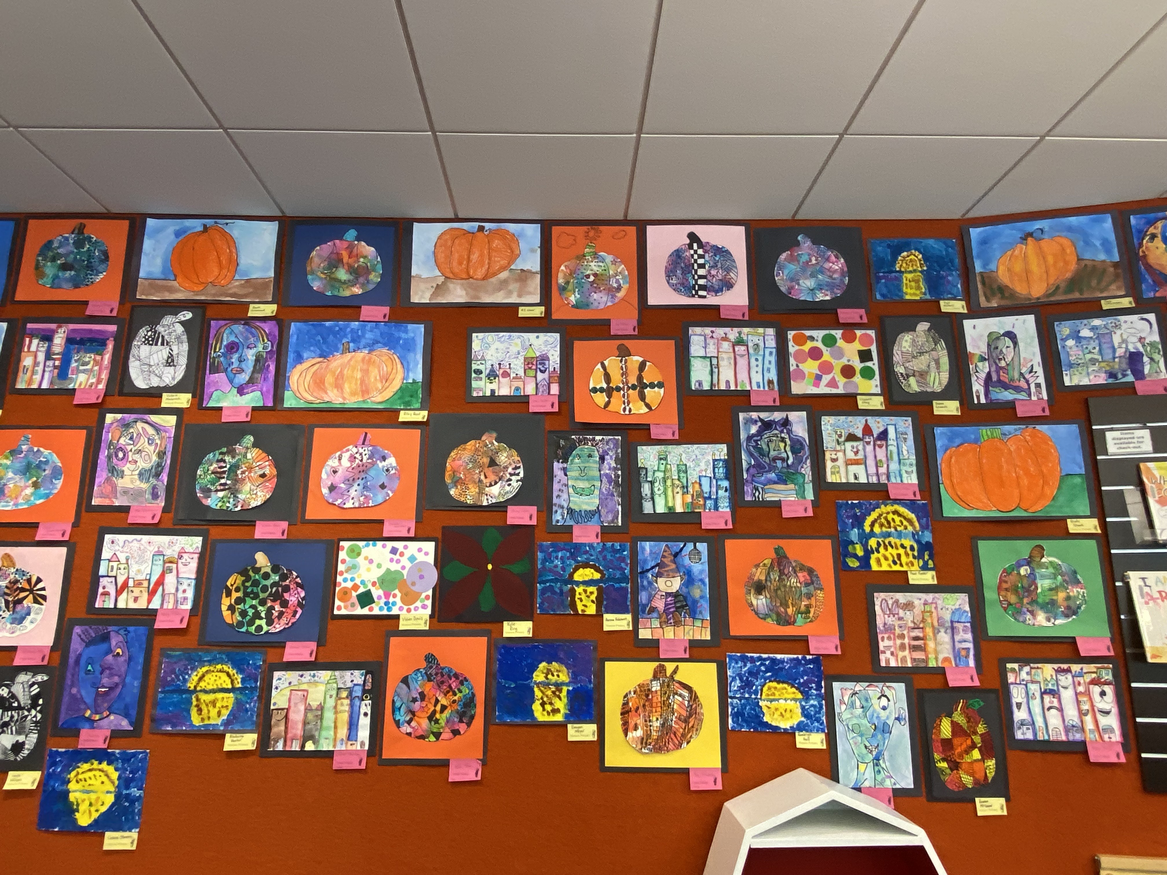 variety of art on green wall with labels