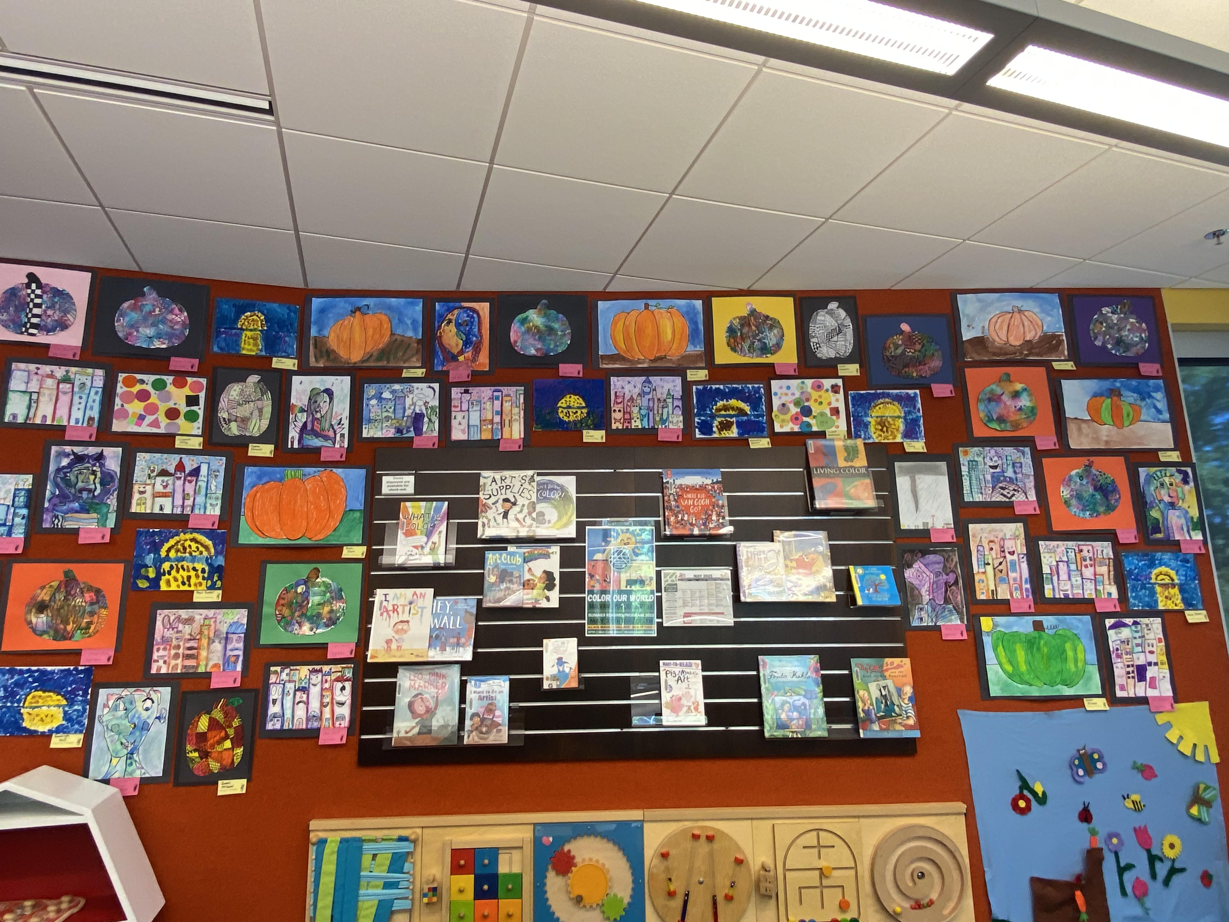 variety of art on orange wall with labels