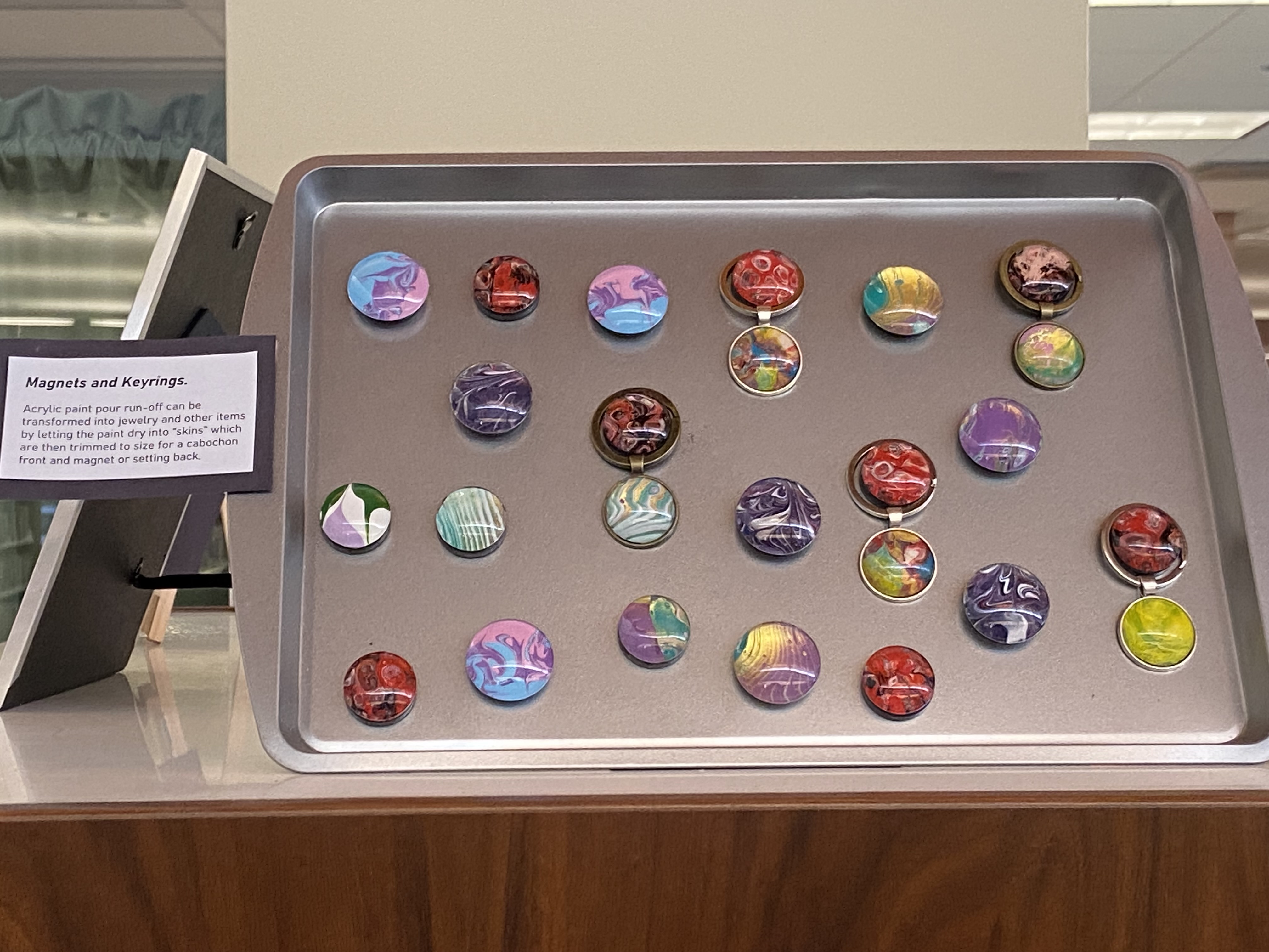 handmade magnets and keyrings on cookie sheet