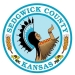 Round teal and white logo with wheat, sunflowers, and the keeper of the plains