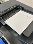 black printer feeder tray and a paper that says fax cover sheet