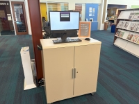 Cabinet with computer set up on top and a sign that says Print Release Station